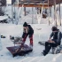 Höfats TRIPLE 120 Bålfad i Corten stål med brændende træstammer, placeret på en hvid overflade. Bålfadet har et moderne design o